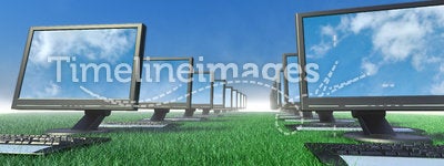 Row of computers in a field of grass.