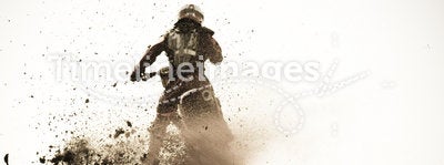 Motocross racer roosts dirt berm on track.