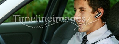 Businessman in car with bluetooth