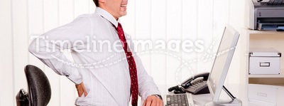 Man in office with computer and back pain